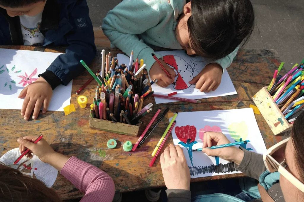 Diese vier Kinder aus Düsseldorf hätten ohne Spenden niemals an diesem Tisch sitzen und ein Bild malen können - und dabei Gemeinschaft, Wertschätzung und Teilhabe erleben.